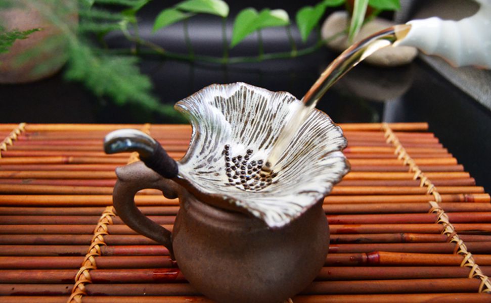 粗瓷茶器：定瓷银杏叶茶漏摆放在茶台上